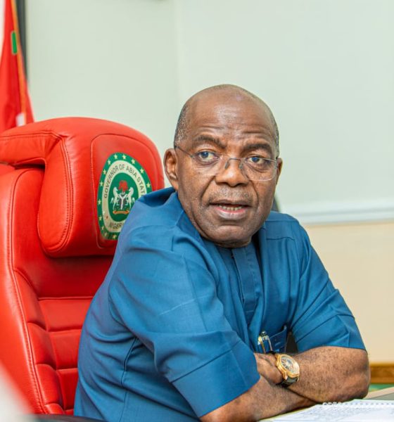 Governor Alex Otti seating on the Governor's seat with folded arms on the table, looking at camera